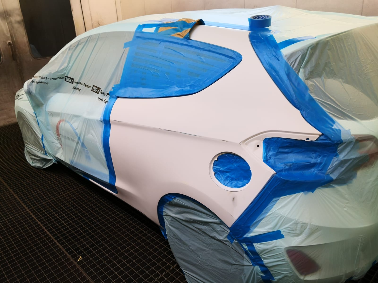 Schrägheck-Seite weiß grundiert und für die Lackierung abgeklebt bei TUNA Fahrzeugtechnik