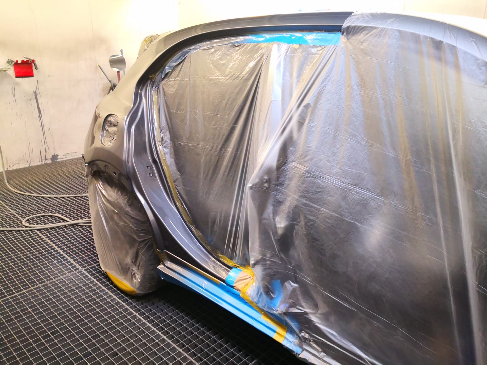 Grau grundierter Frontkotflügel und Tür während der Lackierung bei TUNA Fahrzeugtechnik